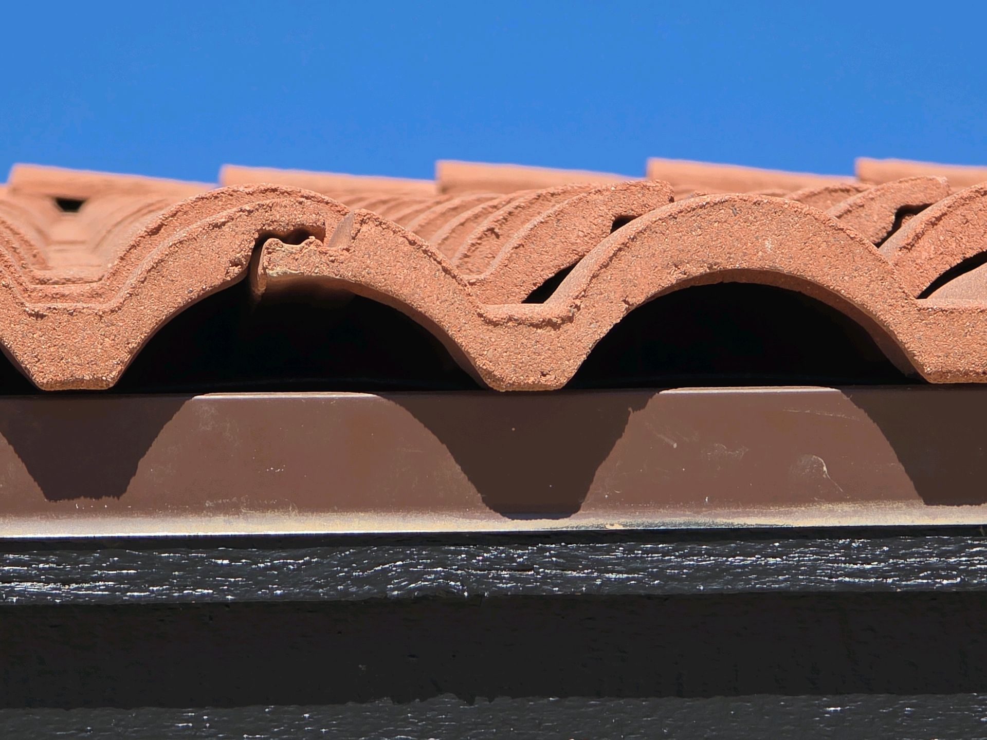 Concrete roof tiles at the eave with open gaps and no bird stops