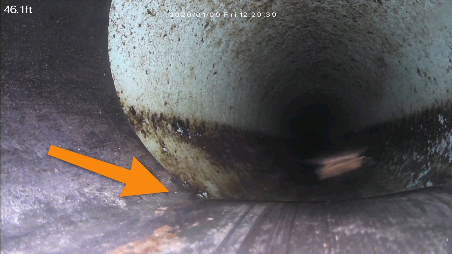 Sewer camera view of standing water in a sagging section of pipe